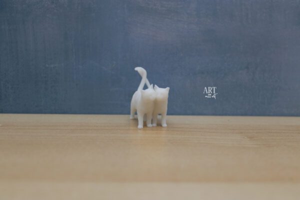 Set van twee miniatuur katten in schaal 1:12, liefdevol naast elkaar lopend met krullende staarten en tegen elkaar aanleunende kopjes, afmetingen 4 cm x 2,2 cm x 3,6 cm