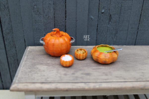 voorbeeld Miniatuur pannenset in schaal 1:12 in de vorm van pompoenen, inclusief een grote dichte pan, een pan met lepel en twee kleine kommetjes, perfect voor Halloween decoratie.