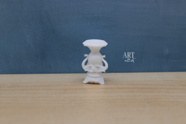 1:12 schaal miniatuur kandelaar met drie gedetailleerde olifantenkoppen, elegant vormgegeven en geschikt voor klassieke of koloniale interieurs. Afmetingen: 2,2 cm x 3,5 cm hoog